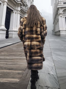 Back view of long fur coat with horizontal striped pattern and full sleeves