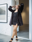 Woman in a black coat standing in a modern interior setting