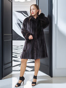 Woman wearing a black fur coat in an indoor setting