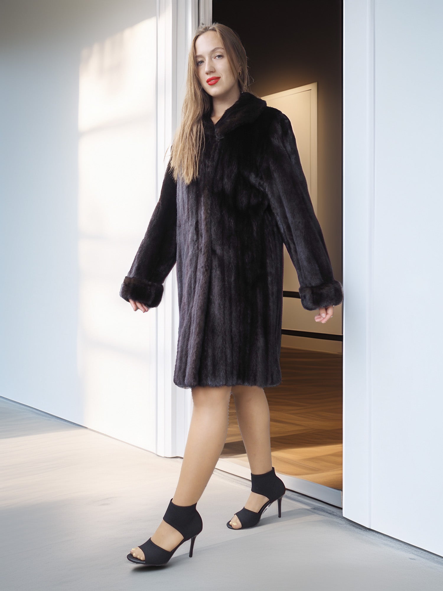 Woman wearing a black fur coat and dress standing in a doorway.
