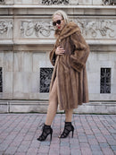 Luxurious vintage Canadian brown mink fur coat, long stroller style, worn by fashionable woman on city street.