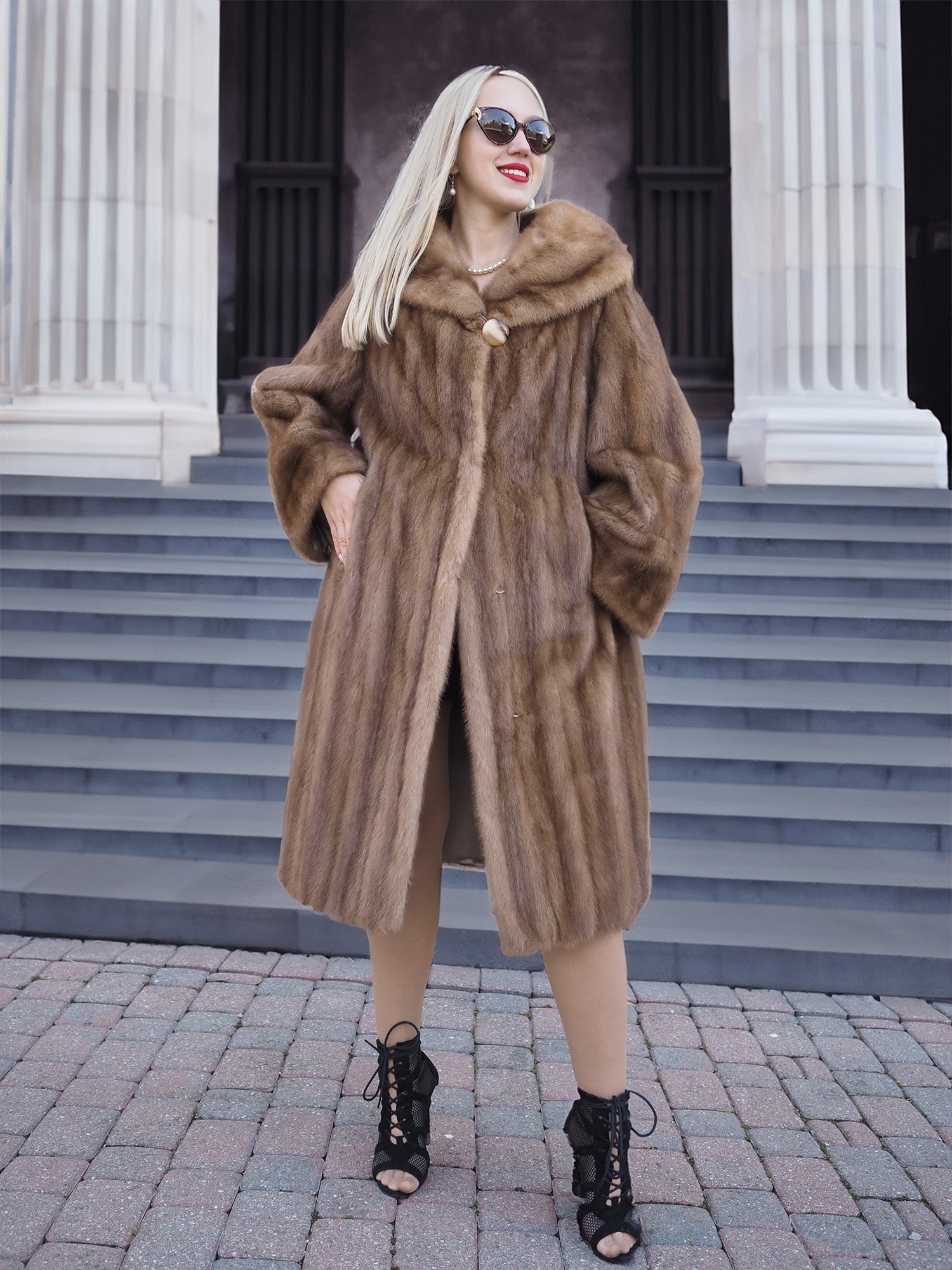 Luxurious Canadian brown mink fur coat with oversized hood, displayed on marble columns.