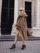 Elegant vintage fur coat with large collar, worn by model outside stone building.