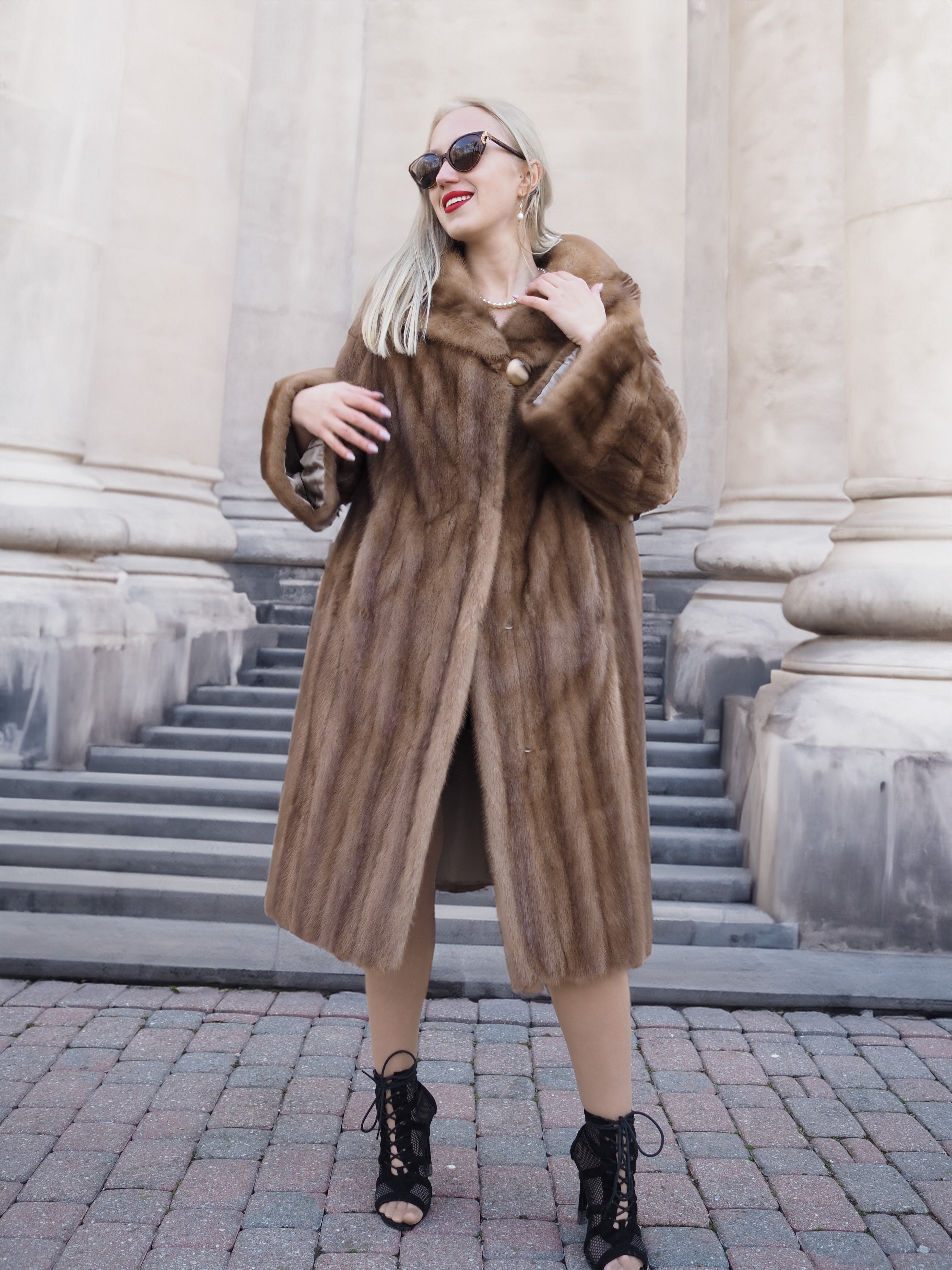 Elegant vintage Canadian brown mink fur coat with plush collar, worn by stylish woman with sunglasses outside stately building.