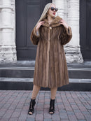 Elegant vintage brown mink fur coat on woman posing in front of building