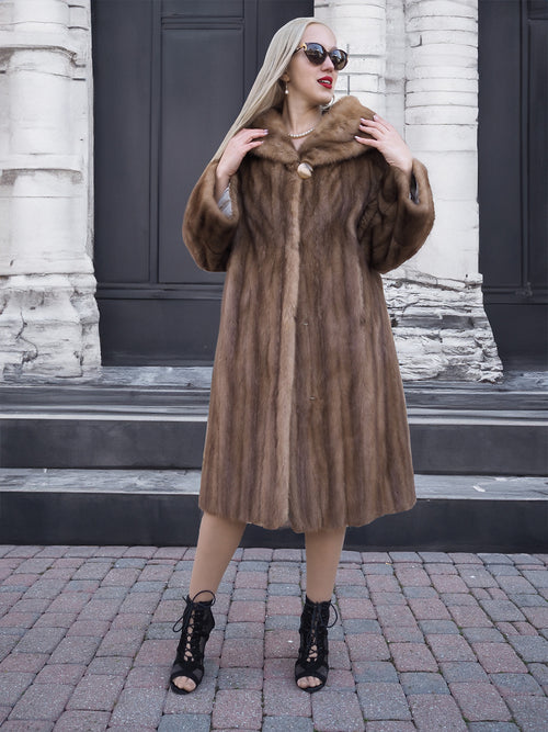 Elegant vintage brown mink fur coat on woman posing in front of building