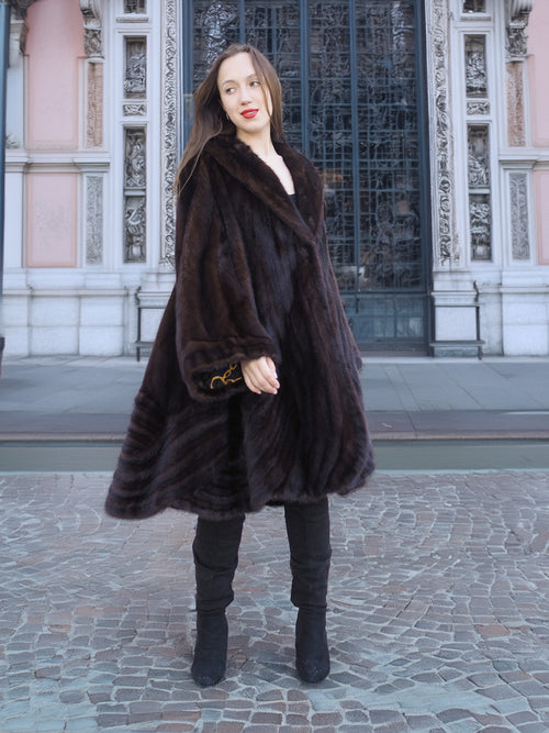 Front-facing model in XL/XXL mahogany mink coat with bell sleeves and flowing hem. Elegant fur outerwear with baroque lining accent.