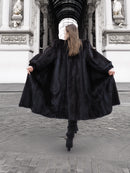 Back view of flowing dark ranch mink fur coat in motion, highlighting natural fur elegance and winter outerwear appeal.