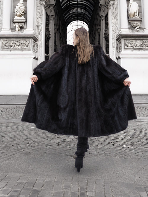 Back view of flowing dark ranch mink fur coat in motion, highlighting natural fur elegance and winter outerwear appeal.