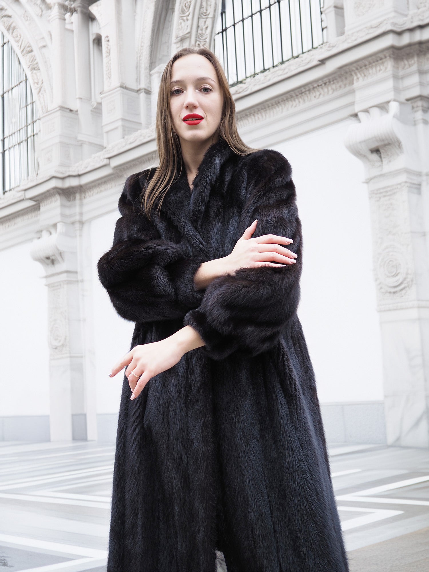Close-up of woman in black mink fur coat with detailed sleeve texture and classic collar, perfect for luxury fur fashion.