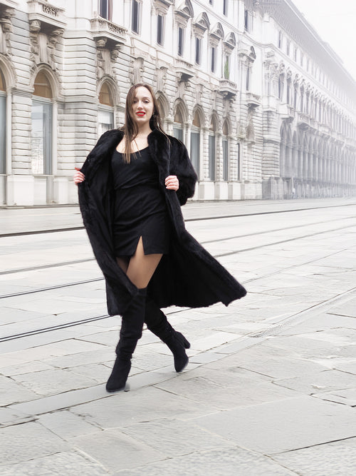 Model in black mink fur coat walking confidently, highlighting the coat’s elegant flow and premium craftsmanship.