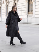 Smiling woman in full-length black mink fur coat with classic cut, ideal for elegant winter outerwear collections.