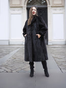 Full-length black mink fur coat with side pockets and structured silhouette, designed for sophisticated cold-weather wear.