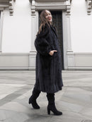 Model walking in classic black mink fur coat with voluminous sleeves and side pockets, ideal for luxury outerwear.