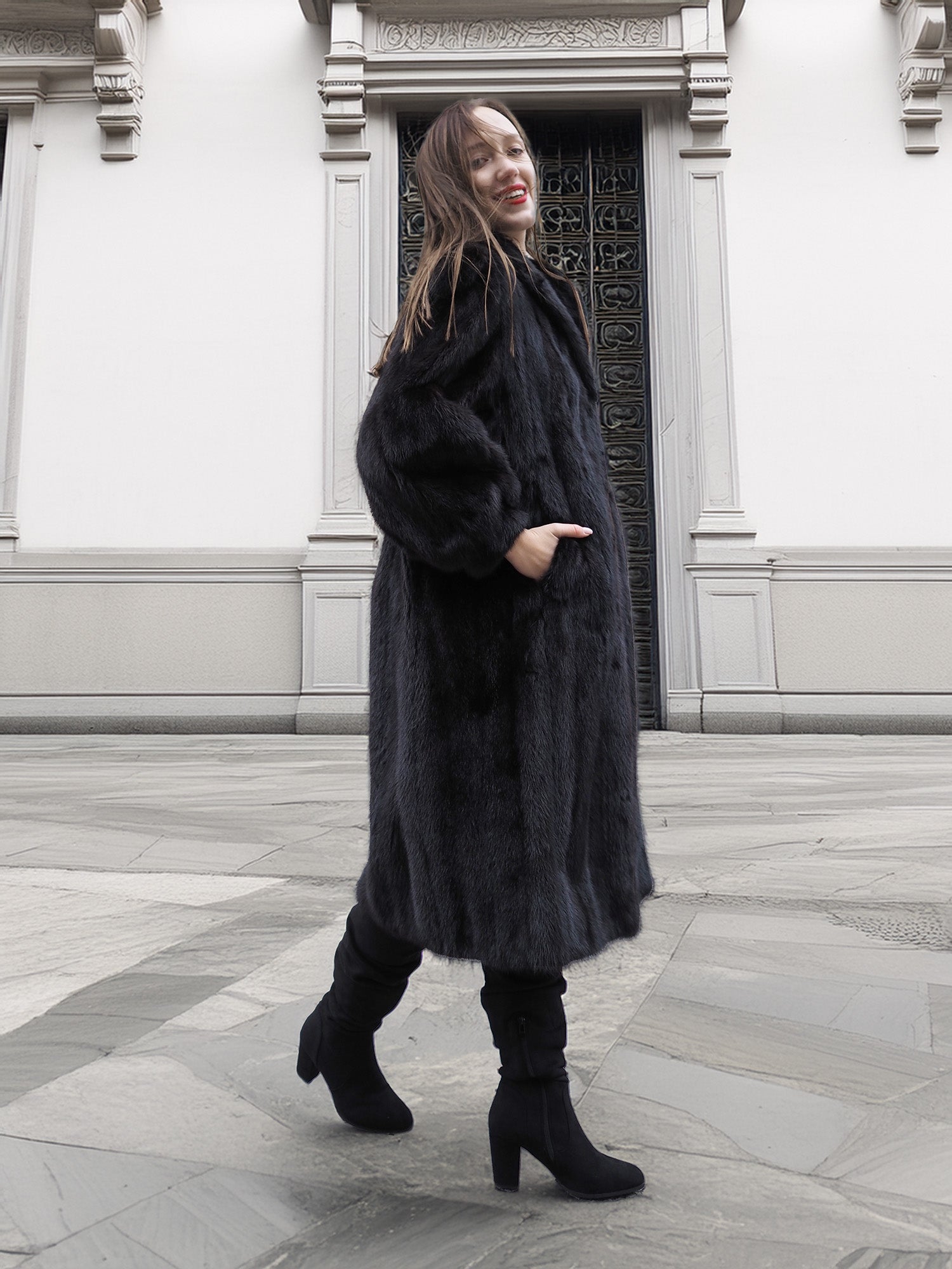 Model walking in classic black mink fur coat with voluminous sleeves and side pockets, ideal for luxury outerwear.