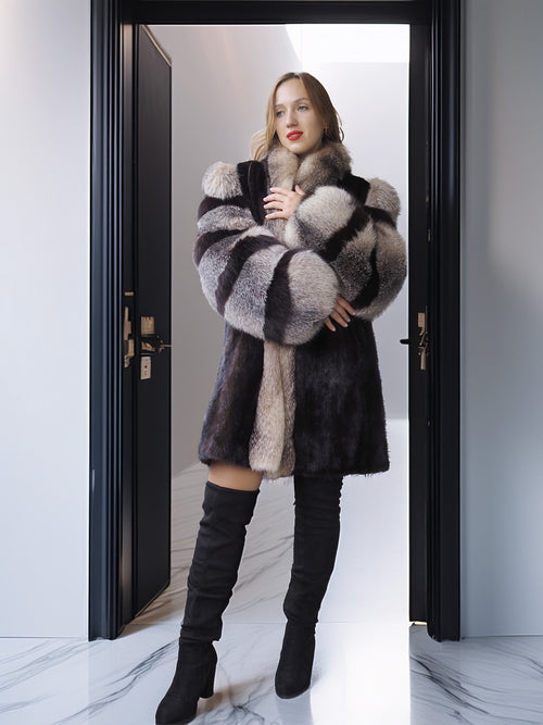 Woman wearing a fur coat and black boots standing in a doorway.