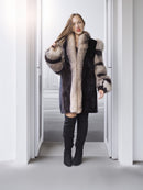Woman wearing a fur coat and black boots in a minimalistic setting