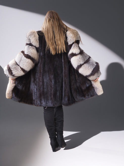 Person wearing a fur coat with a striped pattern on a plain background