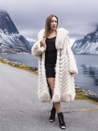 Elegant blue fox fur coat with chevron pattern by snowy lake.