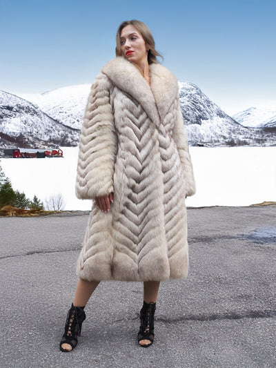 Chic blue fox fur coat with shawl collar in snowy mountains.