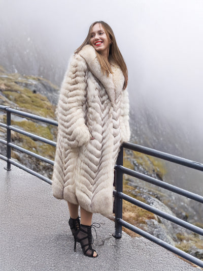 Stylish blue fox fur coat with shawl collar on a foggy day.