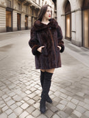 Brown mink coat with wide collar and cuffed sleeves, styled for upscale winter streetwear in a neutral urban backdrop.