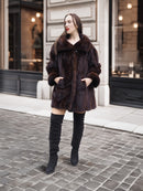 Model posing in vintage mink coat with hands in pockets, showcasing classic fur fashion on cobblestone streets.