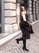 Playful pose with open mink coat, styled with black dress and boots for a chic winter fashion statement.