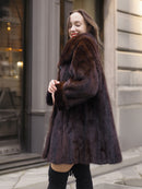 Smiling model in luxurious mink coat, highlighting its soft texture and feminine silhouette for cold-weather elegance.