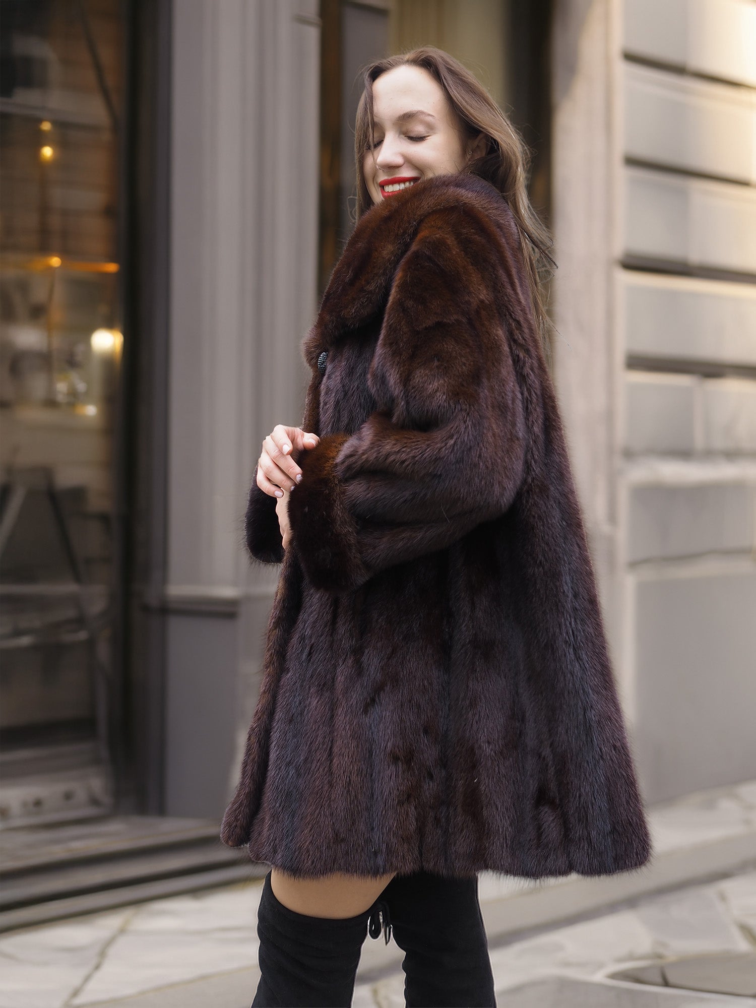 Smiling model in luxurious mink coat, highlighting its soft texture and feminine silhouette for cold-weather elegance.