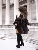 Model spinning in vintage mink coat, showcasing its movement and soft fur texture in a neoclassical architectural space.