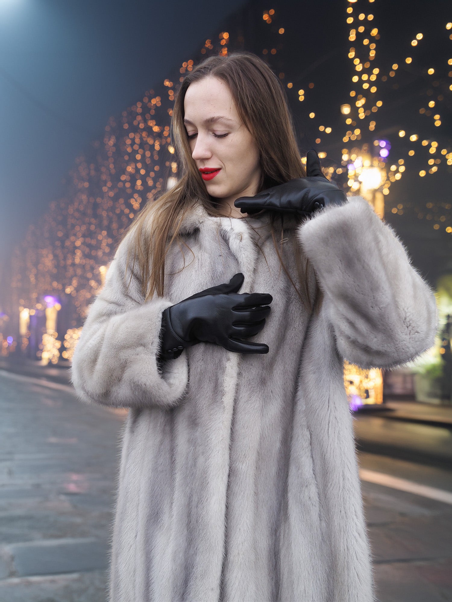 Sapphire Grey Mink Fur Coat S/M Excellent close-up with festive lights. Luxurious fur texture and classic design perfect for holiday fashion statements.