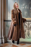 Brown mink fur coat with long sleeves and buttoned front, standing pose