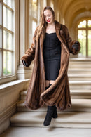 Brown mink fur coat with open front and long draped hem, standing pose