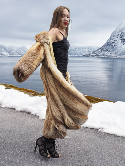 Woman in red fox coat by snowy road