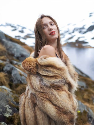 Woman in red fox coat with scenic mountain backdrop