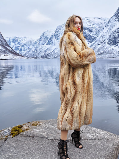 Woman in red fox coat with mountain backdrop