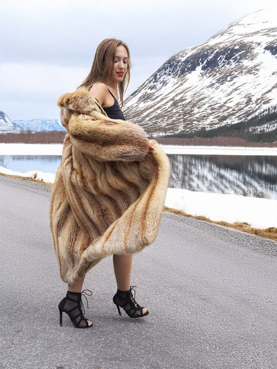 Woman in red fox coat with scenic lake