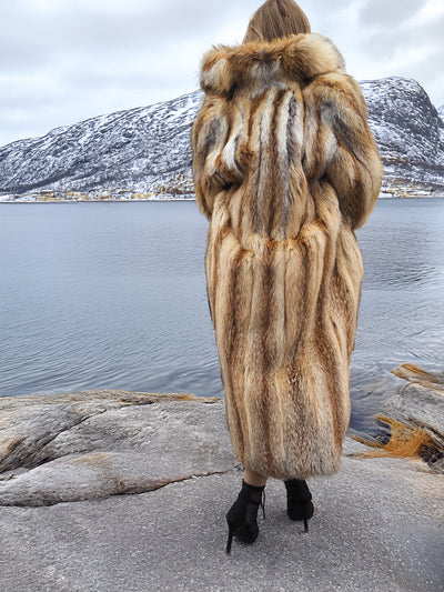 Woman in red fox coat with mountain scenery