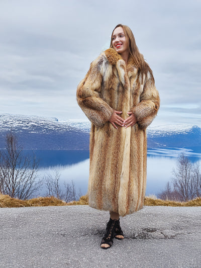 Woman in luxurious red fox coat by lake