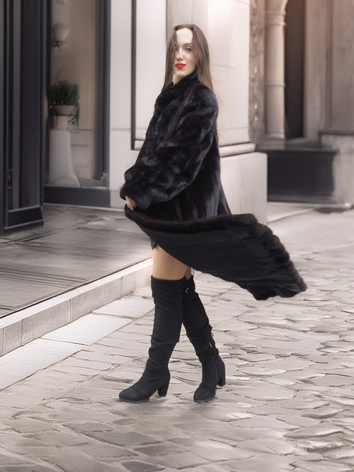 Model twirling in Midnight Sonata black mink coat, emphasizing the dramatic movement and elegance of luxury outerwear.