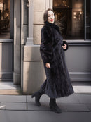 Side view of woman in Midnight Sonata black mink coat, showcasing natural fur sheen and tailored silhouette for winter fashion.