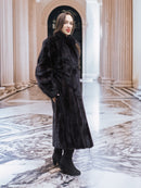 Midnight Sonata black mink coat displayed in a marble hall, highlighting its full-length design and refined fur texture.