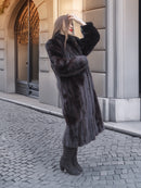 Side pose of woman in Midnight Sonata black mink coat, emphasizing the coat’s natural fur luster and winter-ready style.