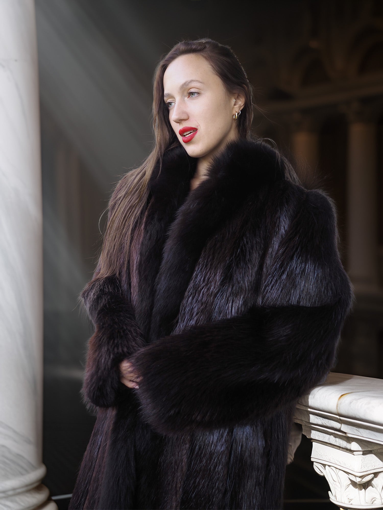 Woman wearing a black fur coat in an elegant setting