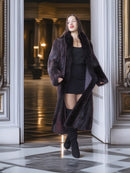 Woman wearing a long fur coat in an elegant interior setting
