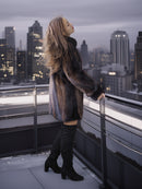 Woman standing on a rooftop with a city skyline in the background