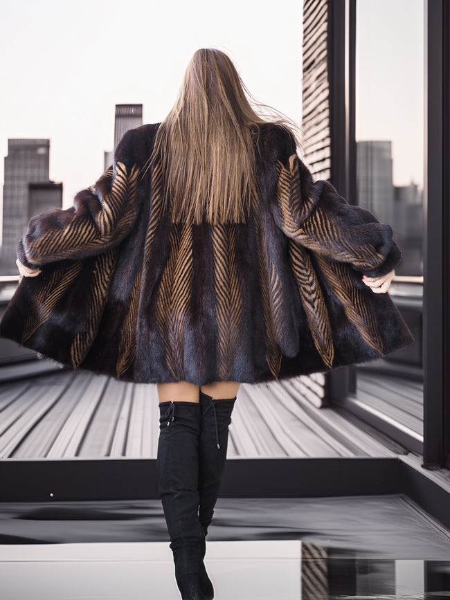 Person wearing a patterned coat and black boots standing on a rooftop with cityscape view.