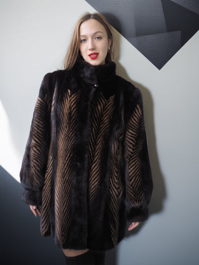 Woman wearing a dark fur coat with geometric wall background