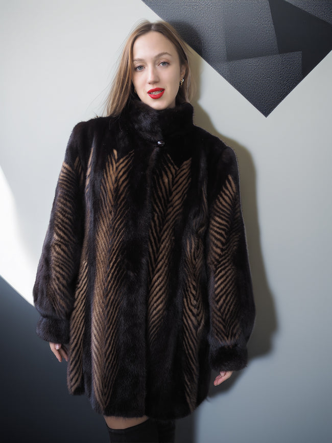 Woman wearing a dark fur coat with geometric wall background